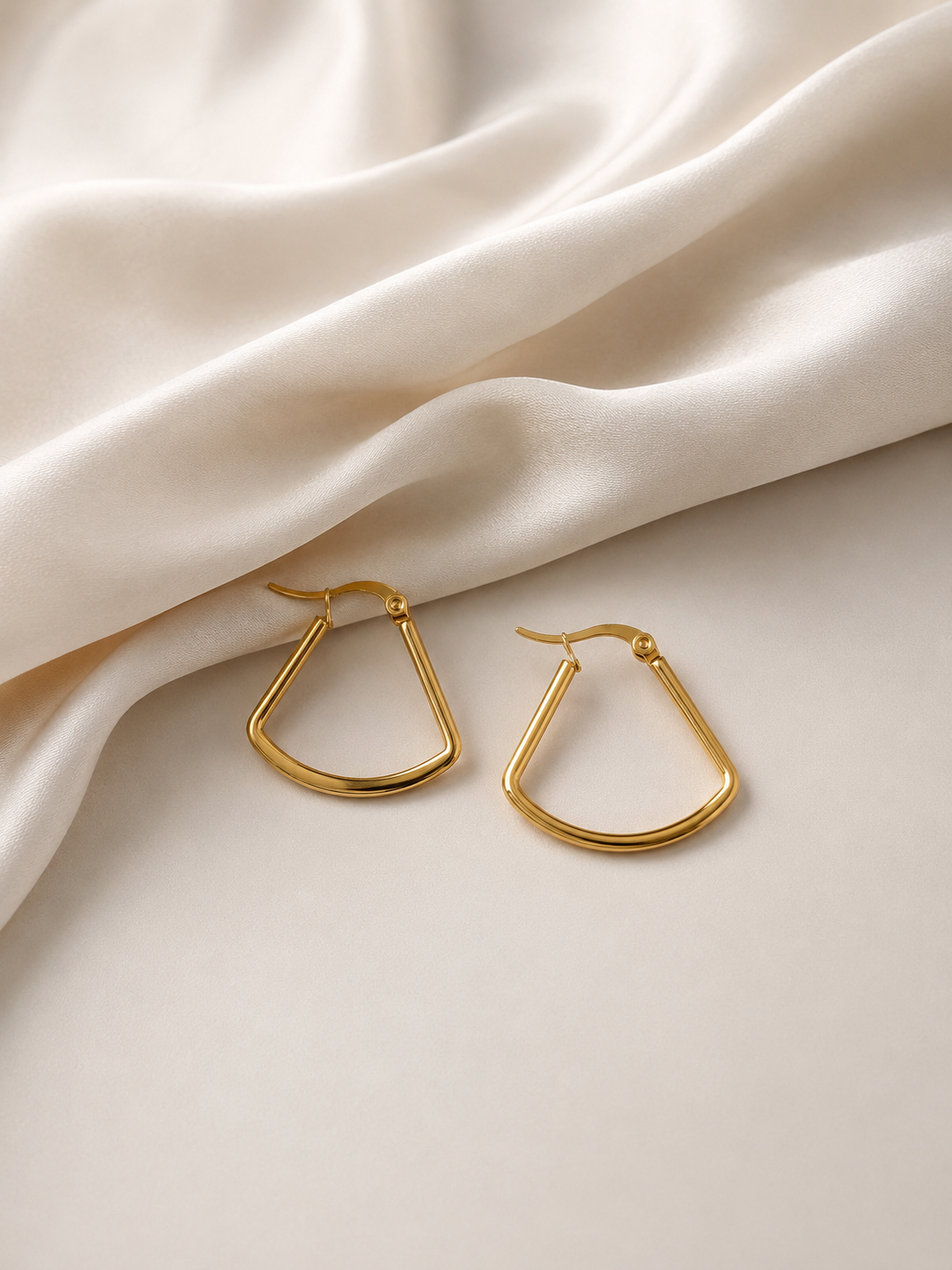 Gold Geometric Trapeze Hoop Earrings on cream fabric