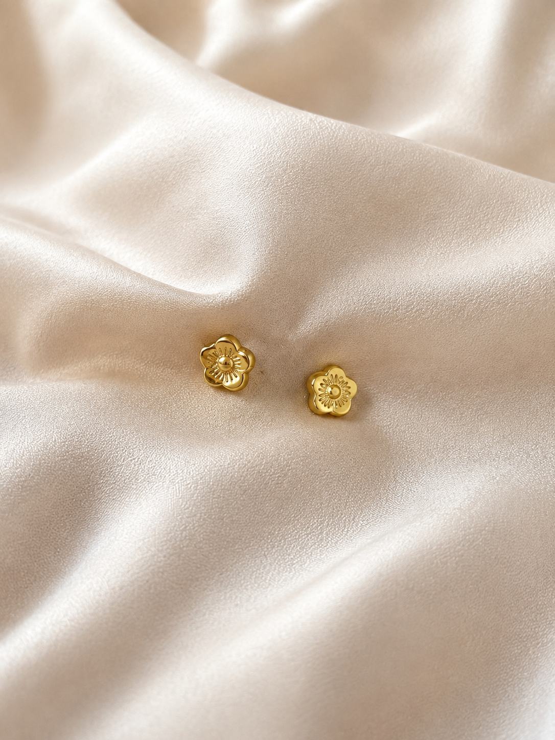 Gold Flower Stud Earrings on cream satin fabric